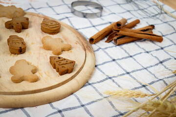 Homemade Christmas ginger bread cookies on wooden try with cinnamon, Xmas gingerbread cookie, preparing bakery, process of baking and cooking at home.