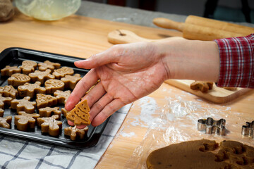 Bakery man's hand holding Christmas gingerbread cookies, homemade cookies before baking, making Xmas ginger bread, preparing bakery, process of baking and cooking at home