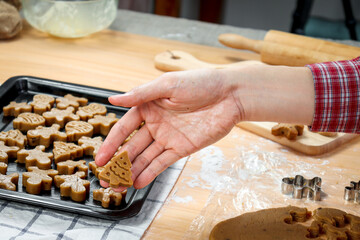 Bakery man's hand holding Christmas gingerbread cookies, homemade cookies before baking, making Xmas ginger bread, preparing bakery, process of baking and cooking at home
