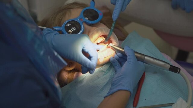 kid girl with oral dilator at dentist's appointment. treatment of teeth