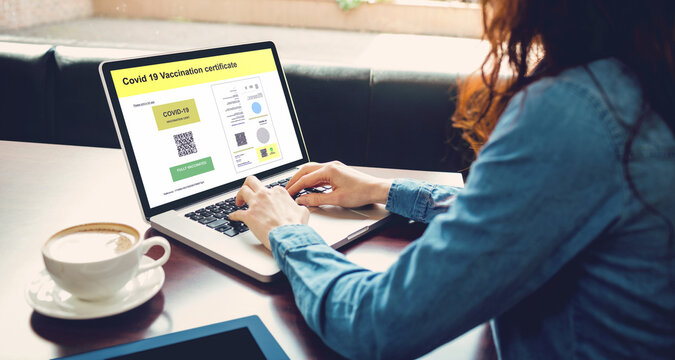 Caucasian woman at cafe using laptop with covid vaccination certificate and qr code on screen