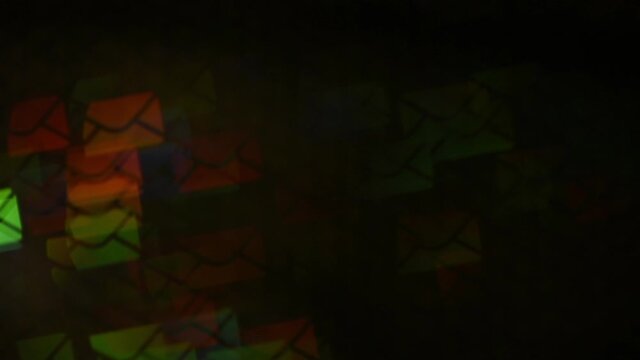 Envelope-shaped bokeh shimmers with different rainbow tones. Moving blurry bokeh with news letters. Envelopes move in light spot from left to right. Movement of Cyber Messages.