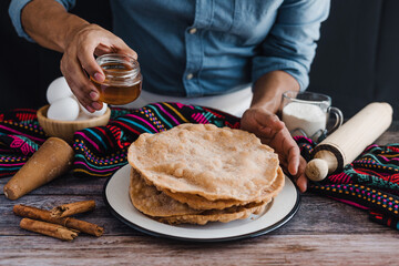 hands of mexican man cooking buñuelos, recipe and ingredients of traditional dessert for Christmas...