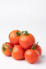 Fresh tomatoes on a green stem on white