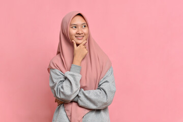 Young Asian muslim woman looking at a copy space or thinking an idea