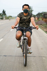 Obraz premium A man cycling with a mask