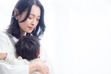 Fototapeta na wymiar A young Asian mom conveys a sense of desperation due to childcare fatigue. 
