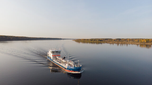 carrying out the carriage of goods by barges along the river. Smooth water, evening light