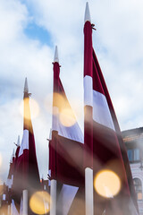 Lots of Latvian red and white flags on the day of proclamation of the Republic of Latvia. Faded...