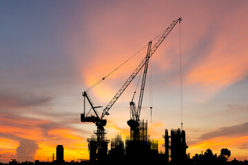 Silhouette of Crane and building construction site sunset sky in evening time