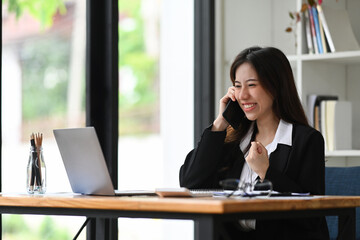Exited businesswoman receiving good news and celebrating her success.