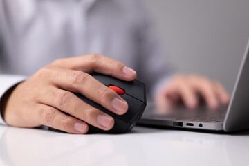 Man hand uses a vertical ergonomic computer mouse joystick.