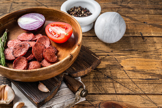Turkish breakfast with Fried sausage sucuk on a rustic plate. Wooden background. Top view. Copy space