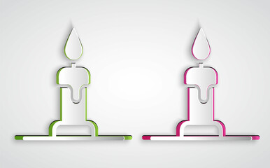 Paper cut Burning candle in candlestick icon isolated on grey background. Cylindrical candle stick with burning flame. Paper art style. Vector