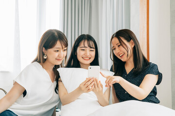 旅行先でスマホを使う女性たち（アプリ）  © buritora