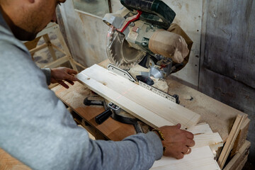Wood processing. Carpenter for cutting wooden bars, work in the workshop. A close shot of the saw. Equipment in the carpentry workshop. 