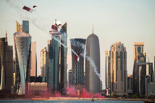 Doha, Qatar - December 18, 2017: Perform of paratroopers with Qatar flags land in a skyscraper area in Doha for national day