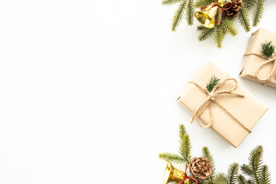 Beautiful Christmas background with two gift boxes, decorate with pine branch and pine cone over white background. Top view with copy space, flay lay.