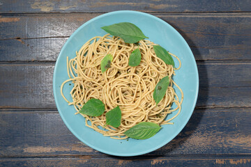 Pasta with pesto sauce in plate on wood background Italian food.