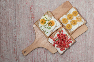 Bread has cream cheese and pomegranate boiled egg banana on red background.