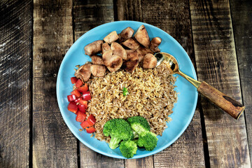 Fried rice with chicken breast has vegetable in plate close up.