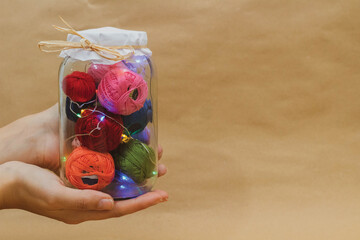 Multicolored threads for embroidery in a jar with lamps in hand