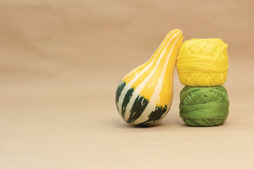 Green and Yellow zucchini on table with leaning against curly green and yellow embroidery thread