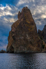 rocks of Cape Fiolent against the background of the evening sky with clouds