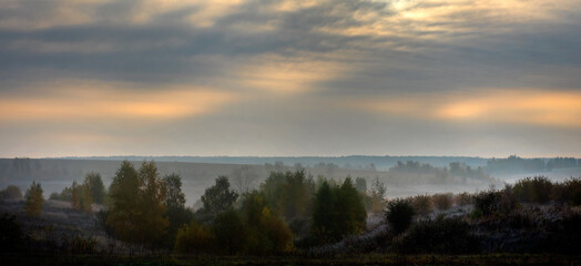 sunrise and morning fog in autumn over a field