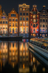 Obraz premium Houses on Water in Night Amsterdam and Pleasure Boat