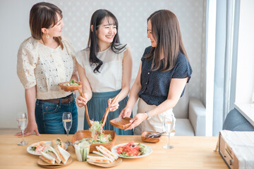 家でパーティーする女性たち(サラダ・取り分ける)