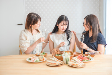 家で悩み相談する女性たち（シャンパン・悩む）
