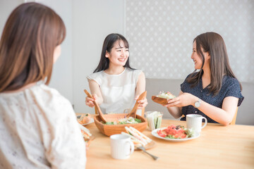 Obraz na płótnie Canvas 食事会で料理を取り分ける女性 