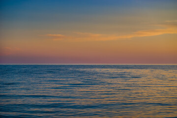 Fototapeta na wymiar bright sunset over the blue sea