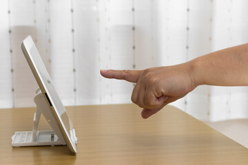 タブレット端末の画面を指さす女の手（日本人、30代)