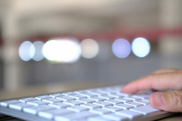 Man using laptop online, seated at office table, staring at computer screen, focused male using internet banking, sending email, and searching for information