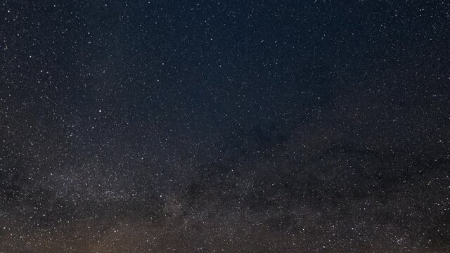 Stars rotating around Polaris star creating startrails at night sky.