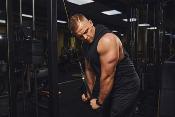 Fototapeta na wymiar Handsome bodybuilder doing heavy weight exercise for triceps while in gym . Bodybuilding concept 