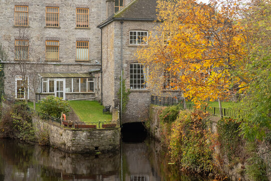Old mill building in Celbridge with autumn colored tree in the foreground. Co. Kildare. Ireland. November 2021