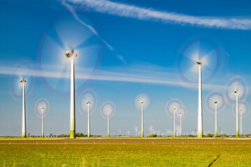 Rotating wind turbines of a wind park with condensation trails crossing the sky-2601