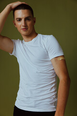handsome man in white t-shirt band-aid on his arm covid vaccine passport