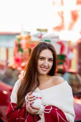 Christmas time for a beautiful young woman with long dark hair happy in the winter street holding gift