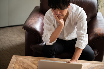 Obraz premium Handsome Asian businessman man thinking while looking at computer Up