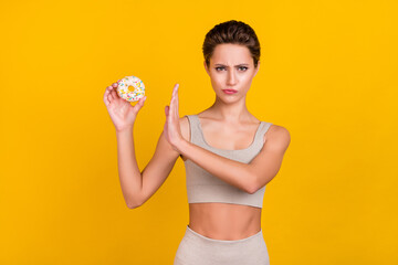 Portrait of attractive sportive girl refusing doughnut no stop sign decision isolated over bright...
