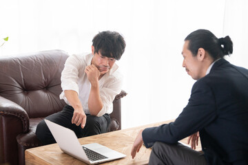 営業さんと話す事務所の代表っぽい日本人の（アジア人）イメージ3　コピースペースあり
