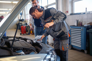 Fototapeta na wymiar car mechanic check the engine oil on the car