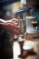 A barman is boiling the milk in the espresso apparatus. Coffee, beverage, bar