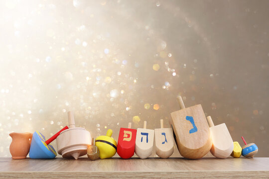 Image of jewish holiday Hanukkah with wooden dreidels collection (spinning top) over glitter background