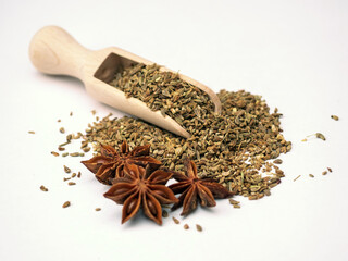 Dry anise seeds in wooden ladle on the white background. Close-up.