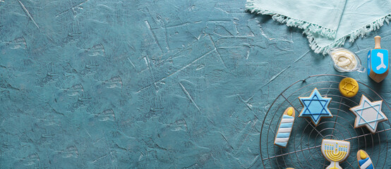 Cooling rack with tasty cookies for Hanukkah celebration on color background with space for text
